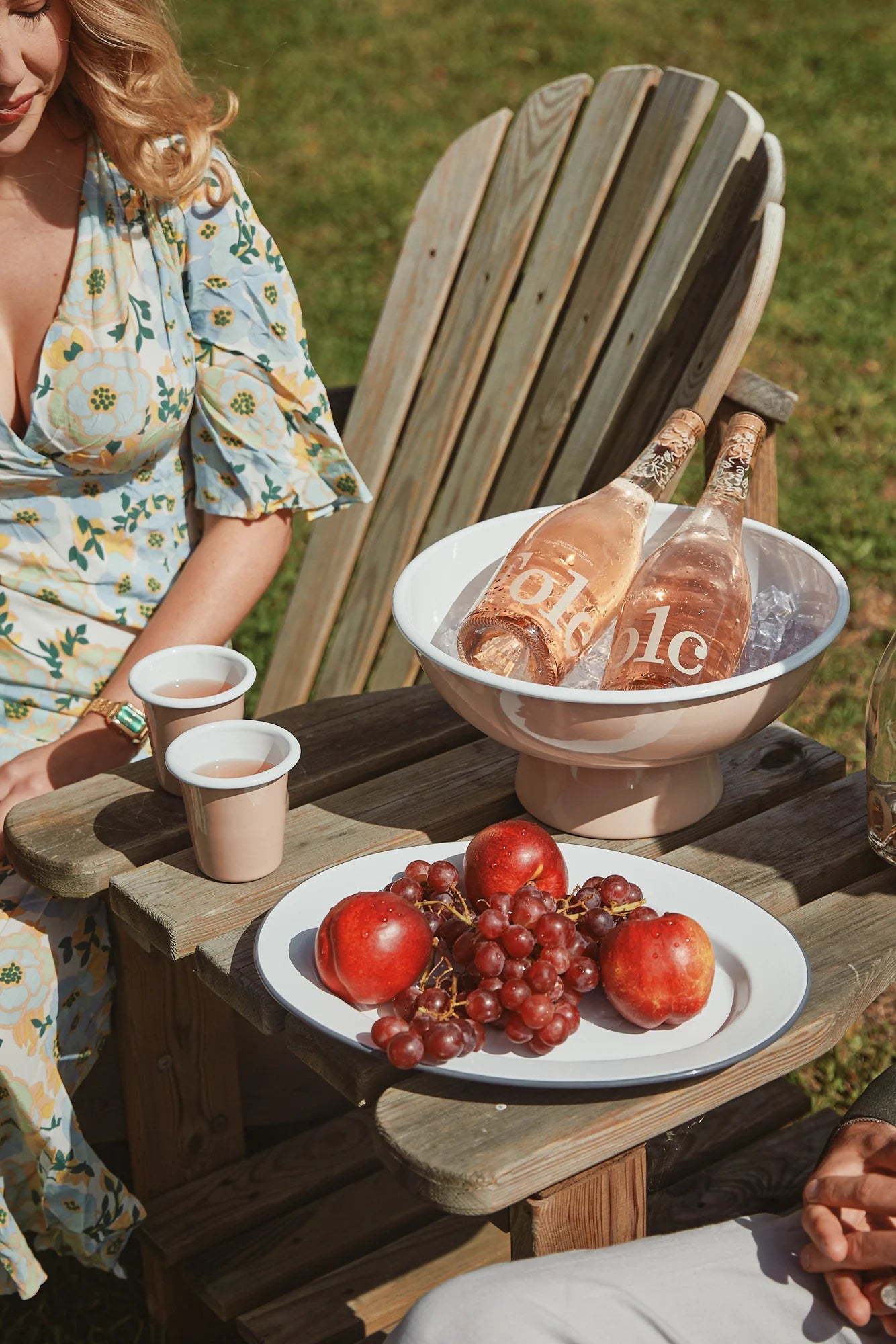 Bottles of Folc rosé on ice beside a plate of fruit in the garden