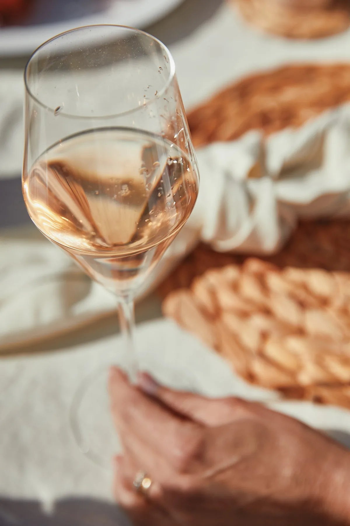 A glass of Folc rosé held at a picnic