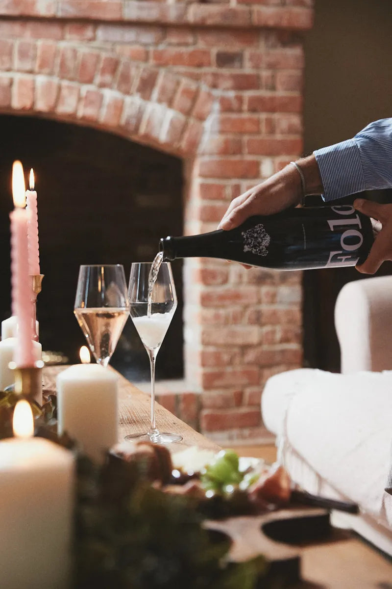 Folc sparkling rosé poured into flutes by a fireplace