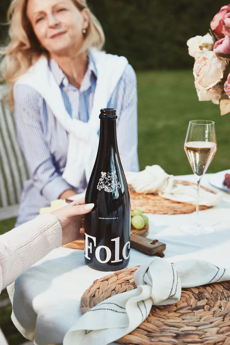A bottle of Folc sparkling rosé on a garden lunch table