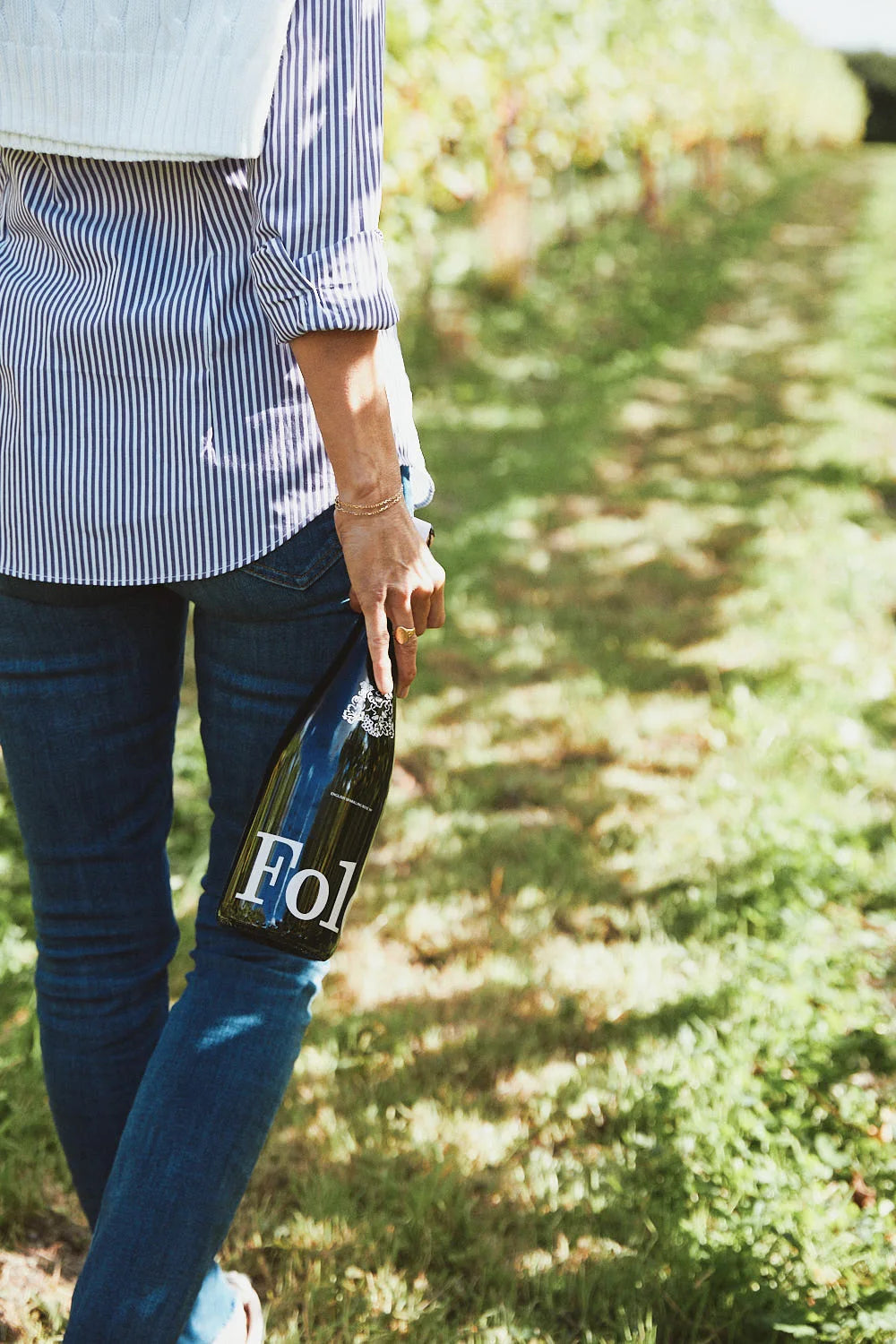 Carrying a bottle of Folc sparkling rosé through the vineyard
