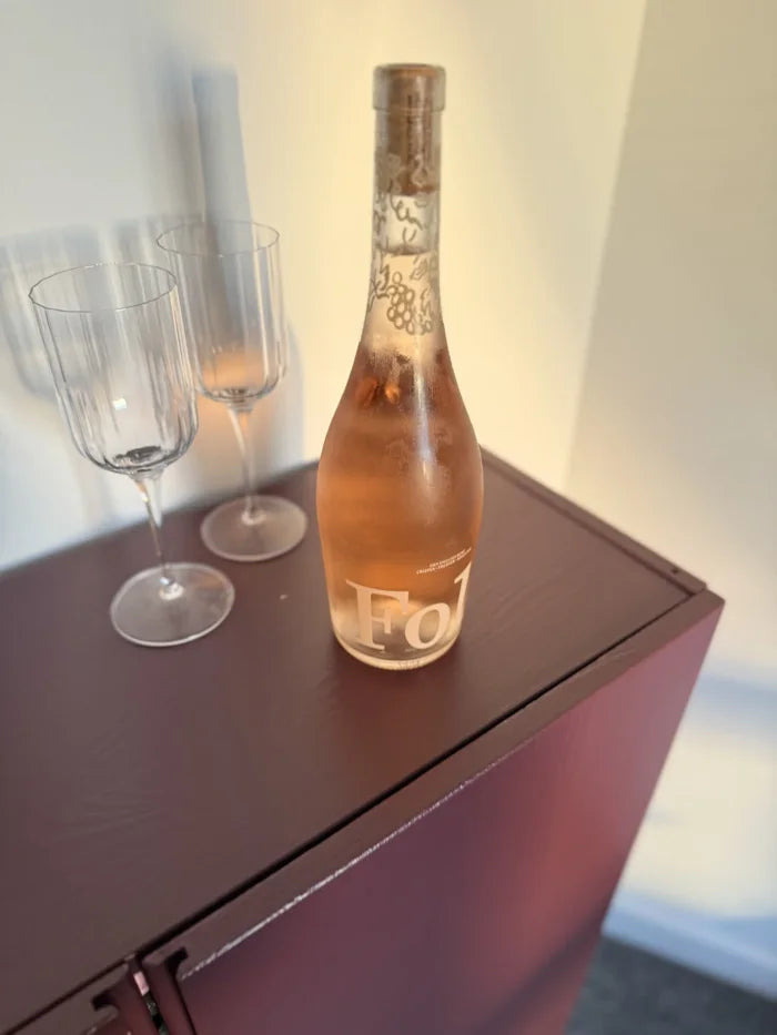 A bottle of Folc rosé beside two glasses