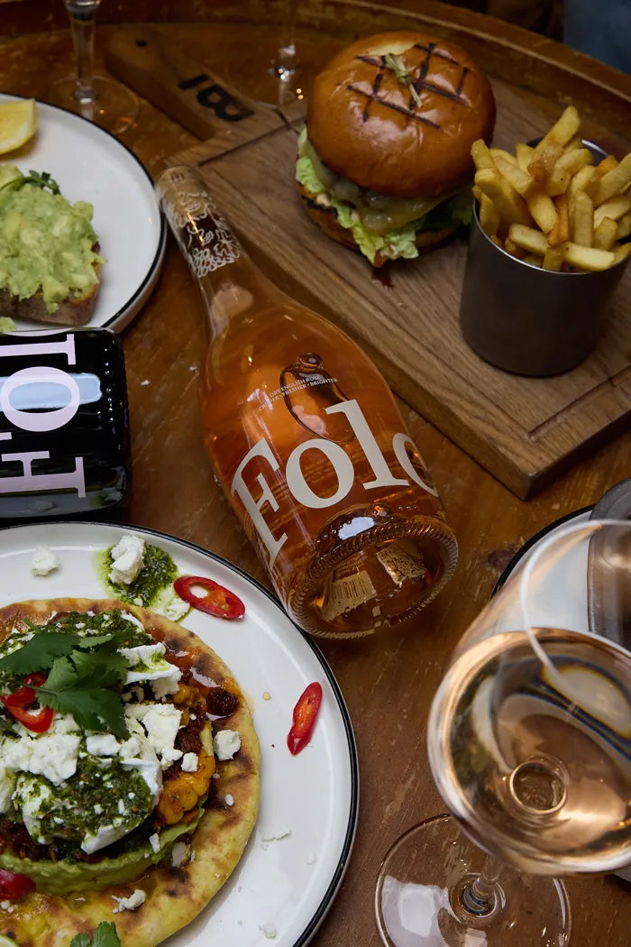 Folc rosé on a pub table with burgers and plates