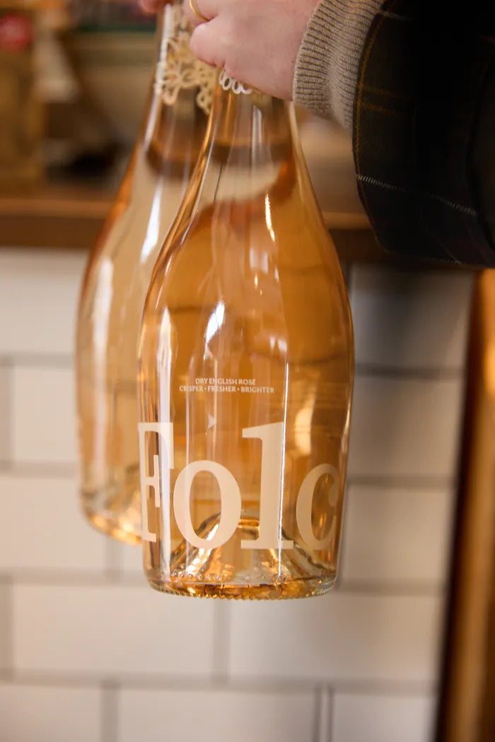 Two bottles of Folc rosé carried in one hand